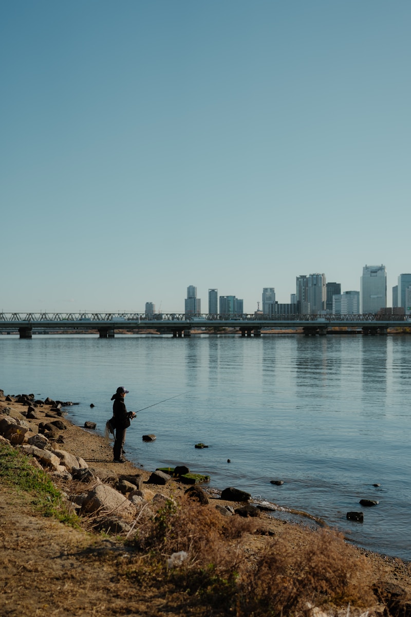 Fisherman casting line by river ,  photo from Unsplash