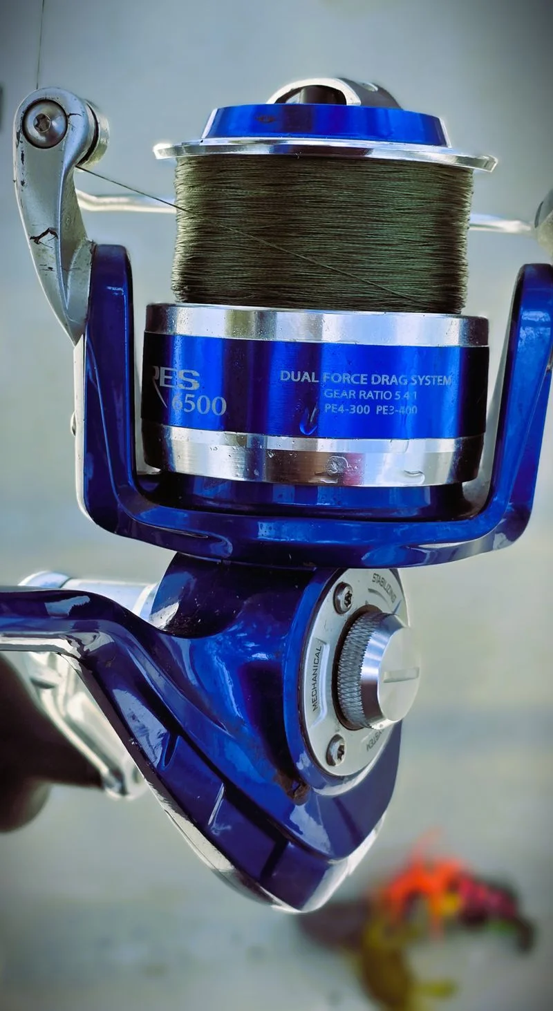 Fishing line spool on a reel showing blue braided line, close-up detail shot